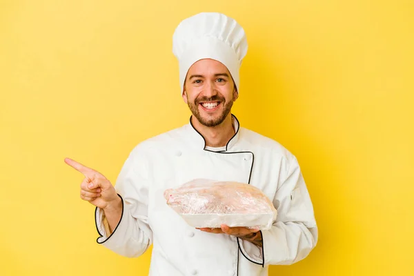 Mladý Kavkazský Kuchař Drží Kuře Izolované Žlutém Pozadí Usmívá Ukazuje — Stock fotografie