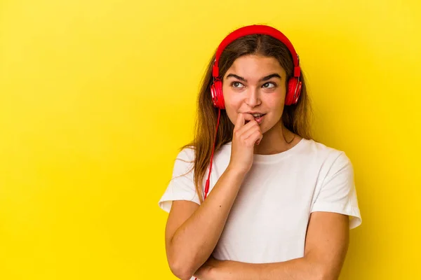 Mujer Caucásica Joven Escuchando Música Aislada Sobre Fondo Amarillo Relajado —  Fotos de Stock