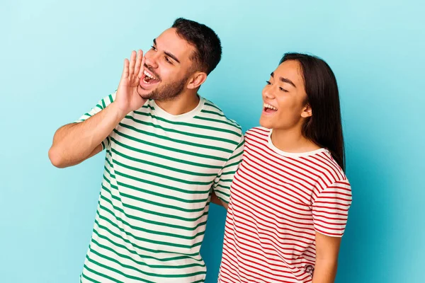 Young Mixed Race Couple Isolated Blue Background Shouting Holding Palm — Stock Photo, Image