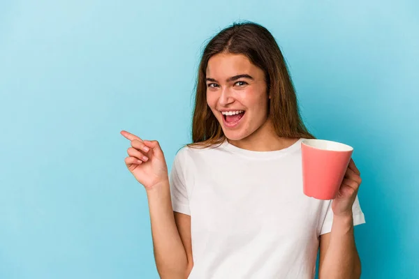 Joven Mujer Caucásica Sosteniendo Una Taza Aislada Sobre Fondo Azul — Foto de Stock