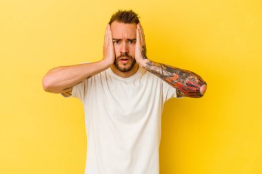 Sarı arka planda izole edilmiş genç dövmeli beyaz adam şok geçiriyordu, önemli bir buluşmayı hatırladı..