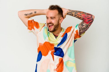 Beyaz arka planda izole edilmiş genç dövmeli beyaz adam çığlık atıyor, çok heyecanlı, tutkulu, bir şeyden memnun..