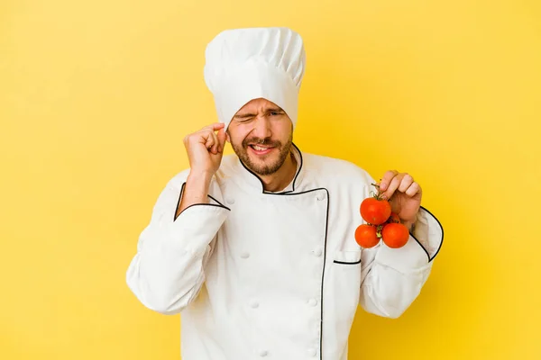 Mladý Kavkazský Kuchař Muž Drží Rajčata Izolované Žlutém Pozadí Zakrývající — Stock fotografie