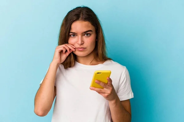 Mujer Caucásica Joven Sosteniendo Teléfono Móvil Aislado Sobre Fondo Azul —  Fotos de Stock