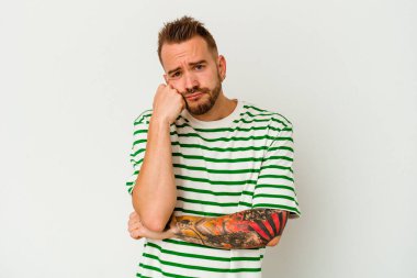 Beyaz arka planda izole edilmiş genç dövmeli beyaz adam tekrarlanan bir görevden yoruldu.