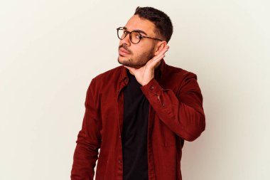 Beyaz arka planda izole edilmiş genç beyaz adam bir dedikoduyu dinlemeye çalışıyor..