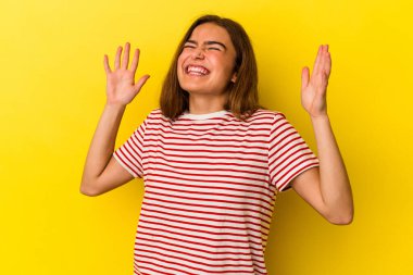 Sarı arka planda izole edilmiş beyaz bir kadın neşeli bir şekilde gülüyor. Mutluluk kavramı.