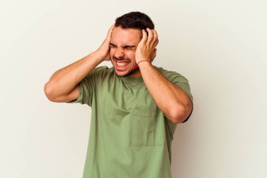 Beyaz arka planda izole edilmiş genç beyaz bir adam kulaklarını elleriyle kapatıyor..