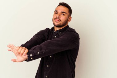 Beyaz arka planda izole edilmiş genç beyaz adam kollarını uzatıyor, rahat bir konumda..