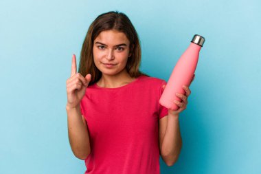 Mavi arka planda su şişesi tutan beyaz bir kadın bir numarayı parmağıyla gösteriyor..