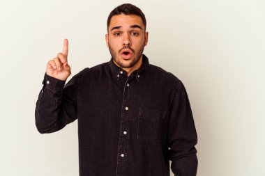 Beyaz arka planda izole edilmiş genç beyaz adam ağzı açık bir şekilde üst tarafı işaret ediyor..