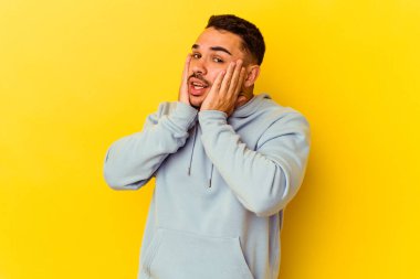 Sarı arka planda izole edilmiş genç beyaz adam korkmuş ve korkmuş..