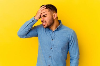 Sarı arka planda izole edilmiş genç beyaz adam tapınaklara dokunuyor ve baş ağrısı çekiyor..