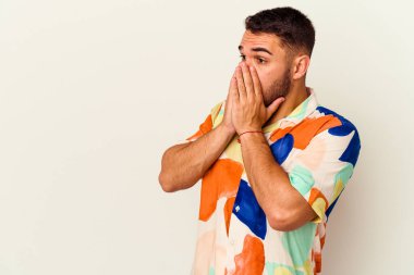 Beyaz arka planda izole edilmiş beyaz tenli genç adam ağzını eliyle kapatan bir fotokopi odasına bakıyor..