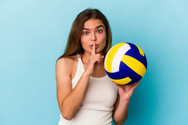 Молода Біла Жінка Грає Волейбол Ізольовано Синьому Фоні Зберігаючи Таємницю — стокове фото