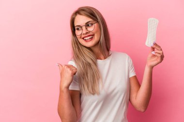 Pembe arkaplan noktalarına sıkıştırılmış genç Rus kadın başparmak uzakta, gülüyor ve kaygısız..