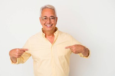 Beyaz arka planda izole edilmiş kıdemli Amerikalı bir adam gömlek fotokopi alanını elle gösteriyor, gururlu ve kendinden emin.