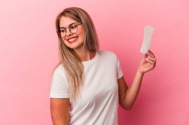 Pembe arka planda izole edilmiş bir kompres tutan genç Rus kadın gülümsüyor ve keyifli görünüyor..