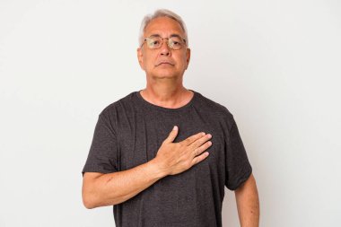 Üst düzey Amerikalı adam beyaz arka planda izole edilmiş yemin ediyor, elini göğsüne koyuyor..