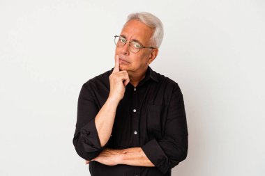 Beyaz arka planda izole edilmiş kıdemli Amerikalı şüpheli ve şüpheci bir ifadeyle yana bakıyor..