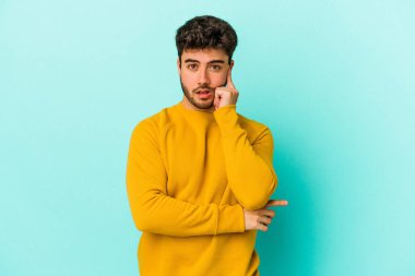 Kafkasyalı genç adam mavi arka planda izole edildi. Harika bir fikri var, yaratıcılık kavramı..