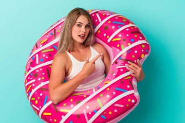 Mavi arka planda izole edilmiş şişme donutu olan genç Rus kadın...