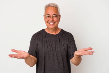 Beyaz arka planda izole edilmiş kıdemli Amerikalı adam kollarıyla ölçeği yapıyor, mutlu ve kendinden emin hissediyor..