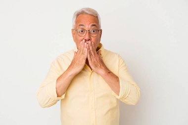 Beyaz arka planda izole edilmiş kıdemli Amerikalı adam elleriyle ağzını kapatırken şok oldu..
