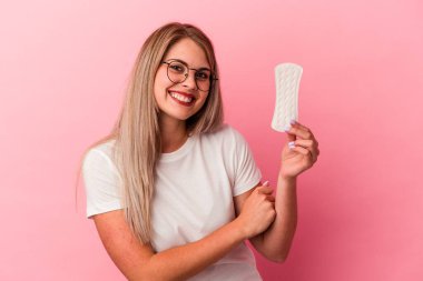 Genç Rus kadın pembe arka planda bir kompres tutuyor. Gülüyor ve eğleniyor..