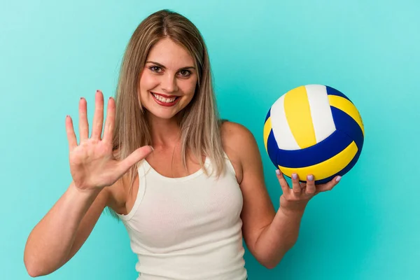Молода Російська Жінка Грає Волейбол Ізольована Синьому Фоні Радісно Посміхається — стокове фото