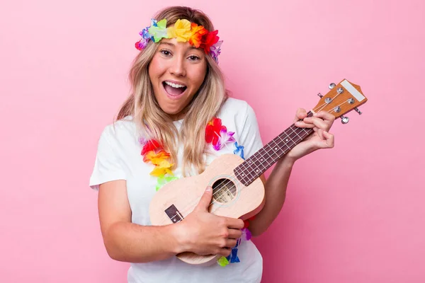 年轻的Hawaiian女人扮演一个被粉色背景隔离的Ukulele — 图库照片