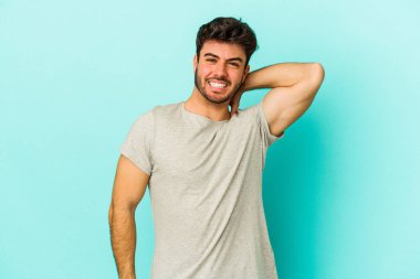 Kafkasyalı genç bir adam mavi arka planda izole edilmiş. Durağan yaşam tarzından dolayı boyun ağrısı çekiyor..