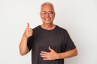 Beyaz arka planda izole edilmiş kıdemli Amerikalı adam karnına dokunuyor, nazikçe gülümsüyor, yemek yiyor ve tatmin oluyor..