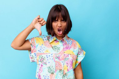 Mavi arka planda izole edilmiş genç bir ırk kadını baş parmağını aşağı gösteriyor ve hoşlanmadığını ifade ediyor..