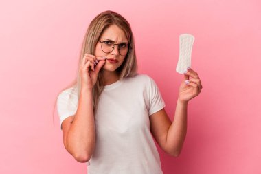 Genç Rus kadın pembe arka planda bir kompres tutuyor parmakları dudaklarında bir sır saklıyor..