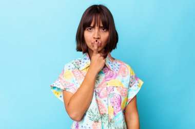 Genç melez kadın mavi arka planda izole edilmiş düşünüyor, bakıyor, yansıtıyor, düşünüyor, hayal kuruyor..