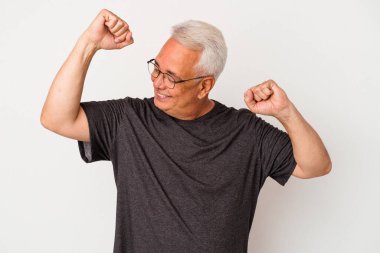 Beyaz arka planda izole edilmiş kıdemli bir Amerikalı özel bir günü kutluyor, atlıyor ve enerjiyle kollarını kaldırıyor..