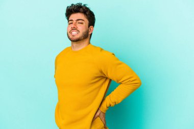 Mavi arka planda izole edilmiş beyaz bir adam sırt ağrısı çekiyor..