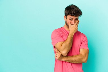 Kafkasyalı genç adam mavi arka planda yalnızdı gülerek, kaygısızca, doğal duygularla.