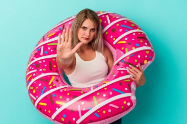 Mavi arka planda, şişme donutlu genç Rus kadın elini uzatmış, dur işaretini göstererek seni engelliyor..