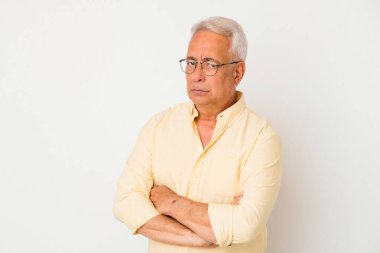 Beyaz arka planda izole edilmiş, hoşnutsuzca kaşlarını çatmış, kollarını kavuşturmuş kıdemli Amerikalı bir adam..
