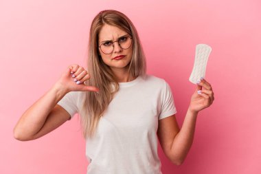 Genç Rus kadın pembe arka planda izole edilmiş bir kompres tutuyordu. Hoşlanmadığı bir hareket gösteriyordu. Anlaşmazlık konsepti.