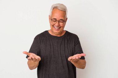 Beyaz arka planda izole edilmiş son sınıf Amerikalı bir adam elinde avuç içi bir şeyle kameraya sunuyor..