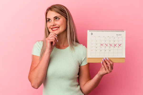 Giovane Donna Caucasica Possesso Calendario Isolato Sfondo Rosa Guardando Lateralmente — Foto Stock