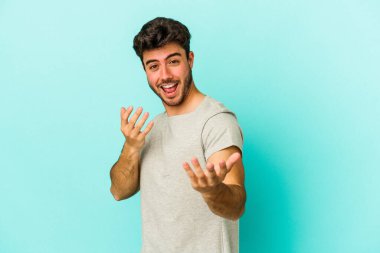 Kafkasyalı genç adam mavi arka planda izole edilmiş seni işaret ediyor sanki davet ediliyormuş gibi..