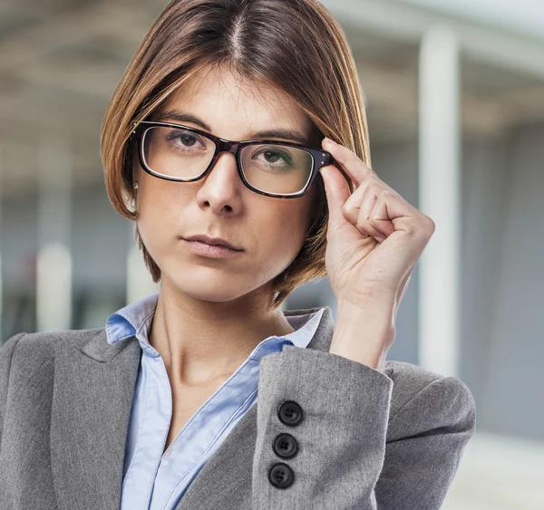 Young woman putting on glasses — Stock Photo, Image