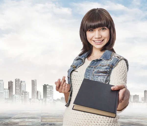 Pretty young woman giving book — Stock Photo, Image