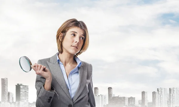 Young woman holding magnifying glass — Stock Photo, Image