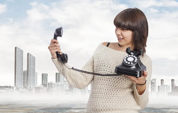 Young woman picking up phone — Stock Photo, Image