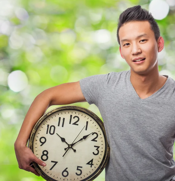 Giovane asiatico uomo holding orologio — Foto Stock